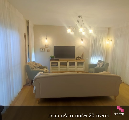 וילונות לבנים שקופים תלויים בסלון מואר